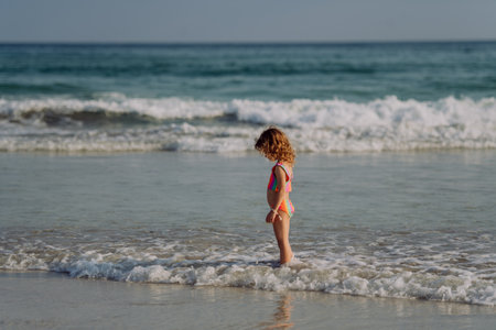 Little girl in swimsuit standing in sea, enjoying holiday.の写真素材