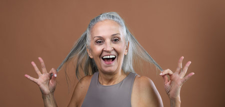 Portrait of smiling senior woman in studio.の写真素材