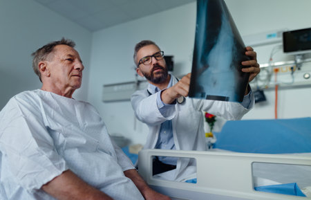 Mature doctor showing elderly patient x-ray image of lungs.