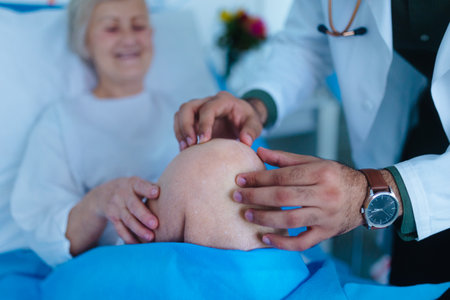 Young doctor examining senior patient in a hospital room.