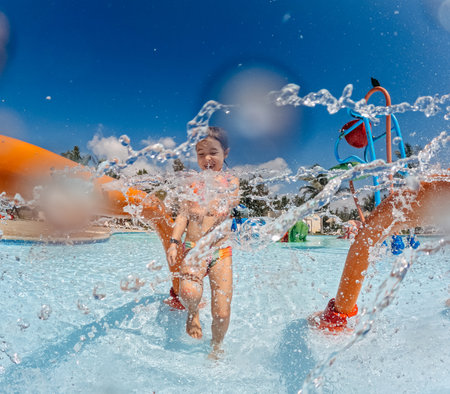 Little girl enjoying water amusement park at family vacation.の写真素材
