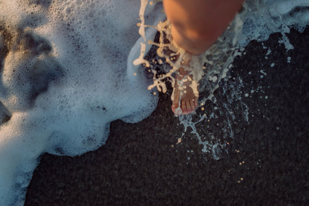 Woman walking on a beach during sunset, close-up of feet.の写真素材