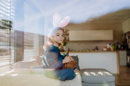 Portrait of little girl holding basket with easter eggs.の写真素材