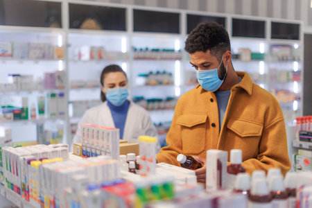 Young pharmacist helping customer to choos medication.