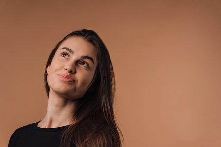 Portrait of young woman in studio, beige background.の写真素材