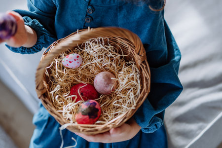 Top view of little girl holding basket with easter eggs.