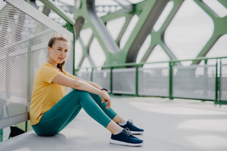 Portrait of young sportive woman resting outdoor in city.の写真素材