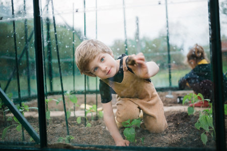 Little children taking care of greenhouse and plants.の写真素材