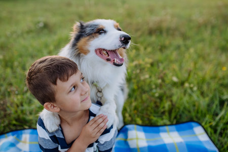 Little boy with collie outdoor, having picnic.の写真素材