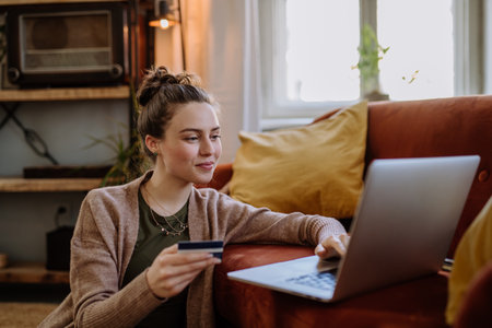 Young woman shopping online in her apartment.の写真素材