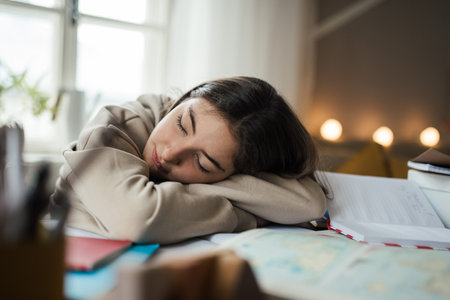 Teenage girl fall asleep during studying in her room.