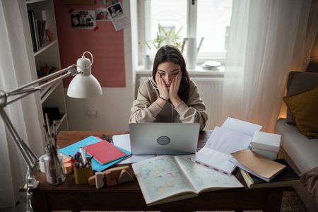 Young teenage girl studying in her room.の写真素材