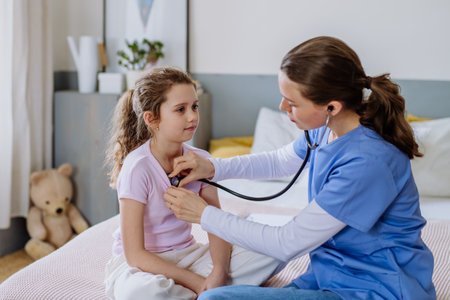 Young doctor taking care of little girl in hospital room.の写真素材