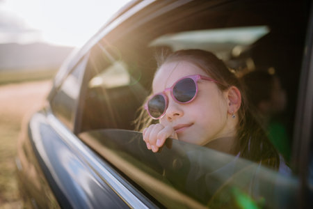Little girl looking out of the car window during the ride.の写真素材