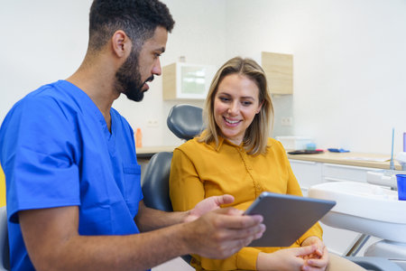 Young woman having consultation with multiracial dentist.の写真素材