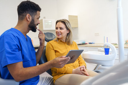 Young woman having consultation with multiracial dentist.の写真素材
