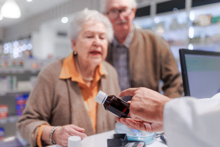 Young pharmacist selling medications to senior couple.の写真素材