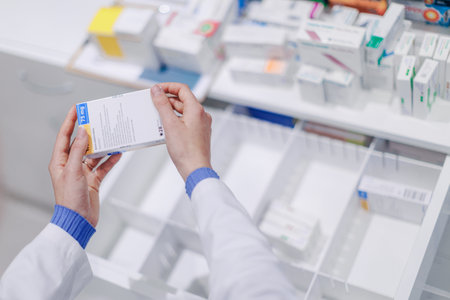 Close-up of pharmacist holding medicines in a pharmacy.の写真素材