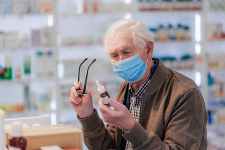 Senior man choosing pills in a pharmacy store.の写真素材