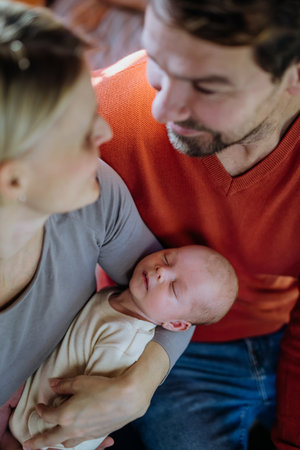 Close-up of parents cuddling their newborn baby.