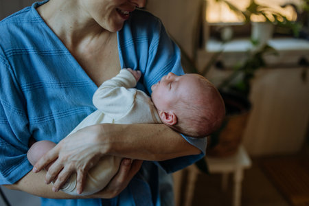 Happy mother cuddling her little newborn baby.