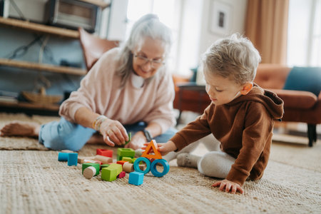 Grandmother playing with her little grandson,building a block set.の写真素材