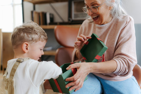 Grandmother giving gift to her little grandson.の写真素材