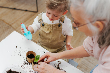 Grandmother with her grandson planting vegetables and flowers.の写真素材