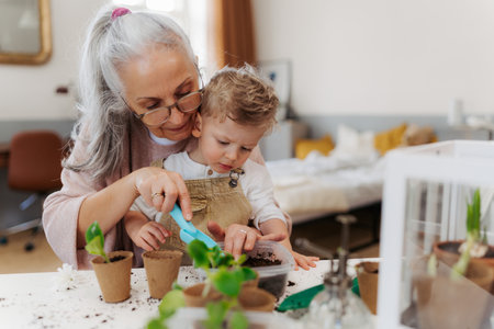 Grandmother with her grandson planting vegetables and flowers.の写真素材