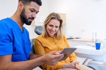 Young woman having consultation with multiracial dentist.の写真素材
