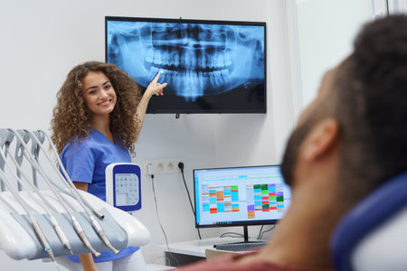 Young dentist showing x-ray image to patient.の写真素材