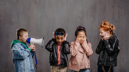 Studio shoot of child with megaphone shouting at other children.の写真素材