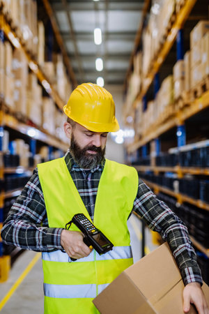 Warehouse worker stocking goods in a warehouse.の写真素材