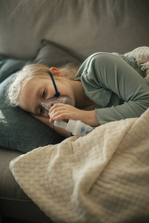 LIttle sick girl using inhaler during flu.の写真素材