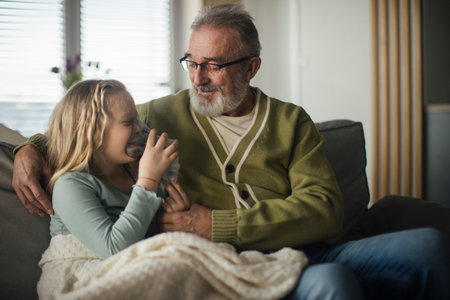 Senior man taking care of his sick granddaughter.の写真素材