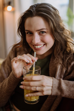 Young woman sitting on sofa with drink.の写真素材