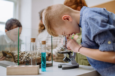 Little boy looking in microscope during science lesson.の写真素材