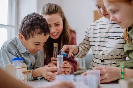 Young teacher doing chemistry experiment with pupils during science education.の写真素材