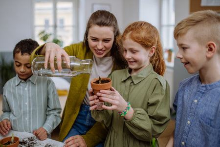 Young teacher learning pupils how to take care about plants.の写真素材
