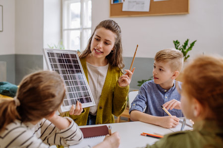 Young teacher with solar panel learning pupils about solar energy.の写真素材