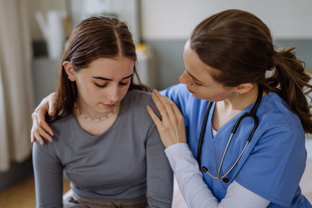 Young nurse taking care of teenage girl, consoling her.の写真素材