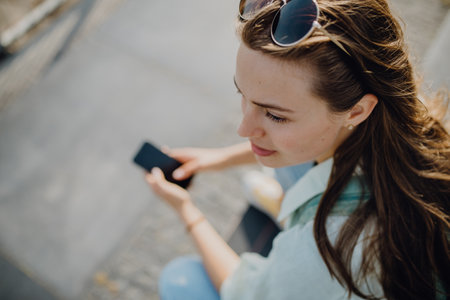 High angle view of young woman with smartphone.の写真素材