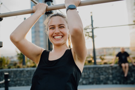 Young woman doing exercises at outdoor work-out city park.
