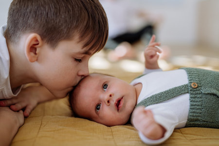 Portrait of boy kissing his younger brother.の写真素材