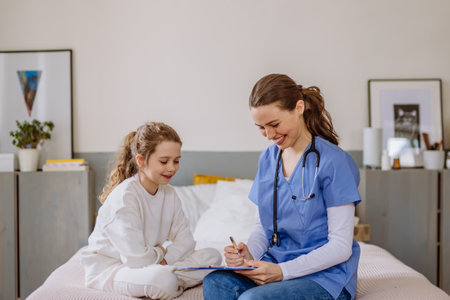 Young doctor taking care of little girl in hospital room.の写真素材