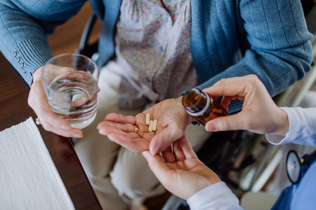 Top view of nurse giving medicine to senior woman at her home.の写真素材