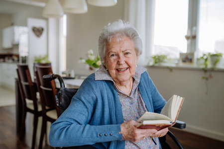 Portrait of senior woman on wheelchair with book.の写真素材