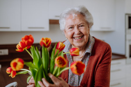 Portrait of senior woman with bouquet of tulips.の写真素材