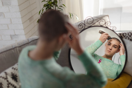 Young woman shaving her hair before chemotherapy.の写真素材