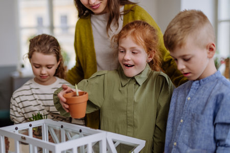 Young teacher learning pupils how to take care about plants.の写真素材